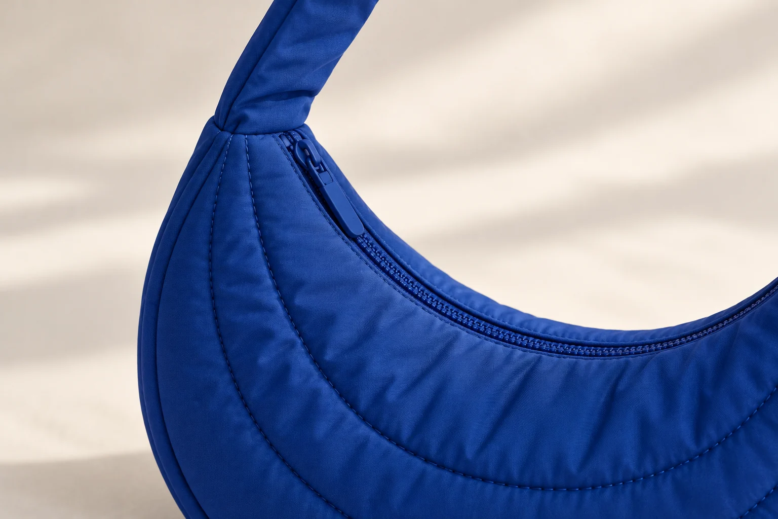 AI concept close-up of rounded blue padded bag channels and the matching broad shoulder strap